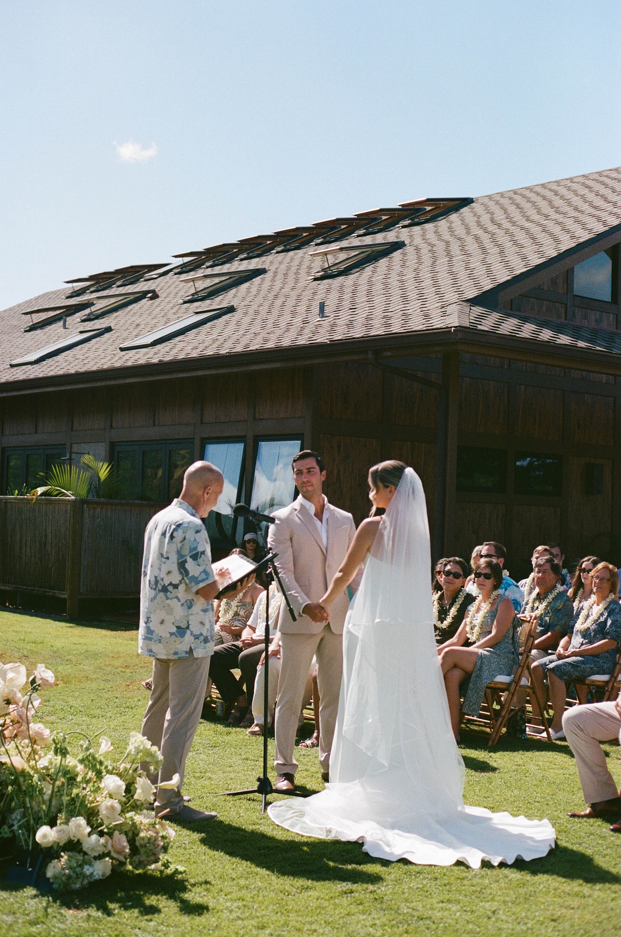 Bride and groom standing together at the alter and looking at the officiant while he recites the vows.