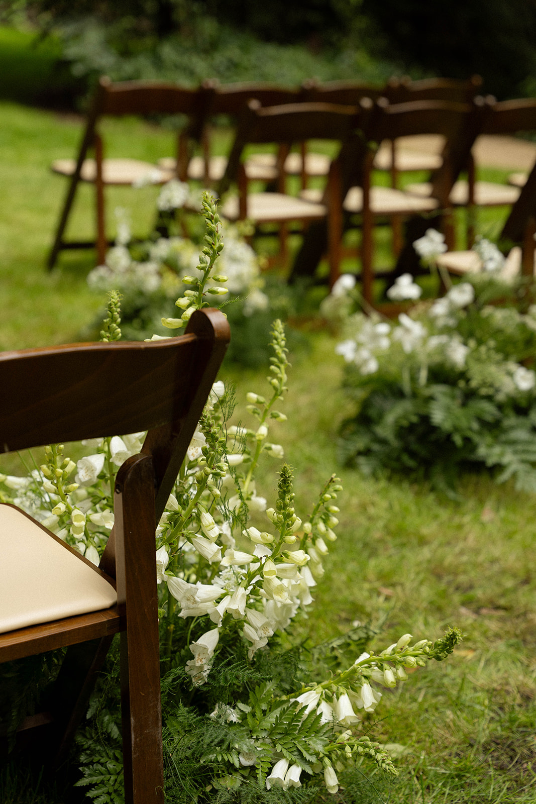 Close-up of the elegant floral arrangements lining the aisle at this forest Big Sur wedding venue.