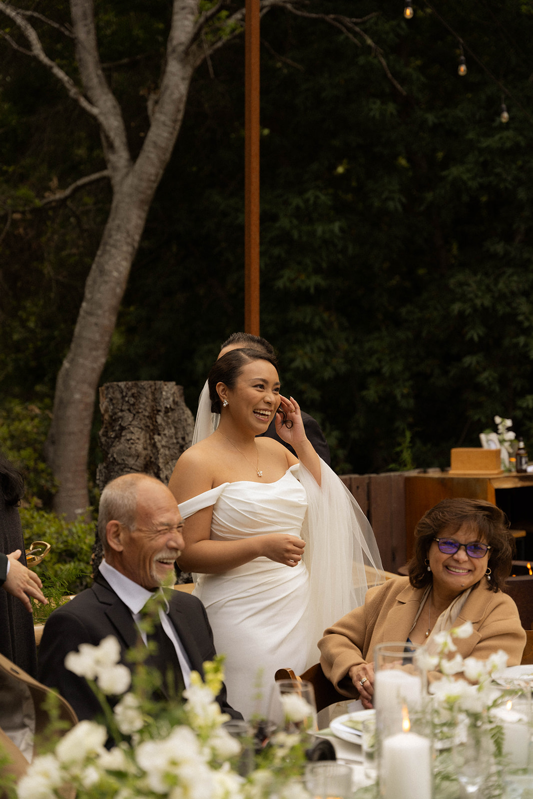 Bride smiling and laughing with family during her Big Sur wedding reception.