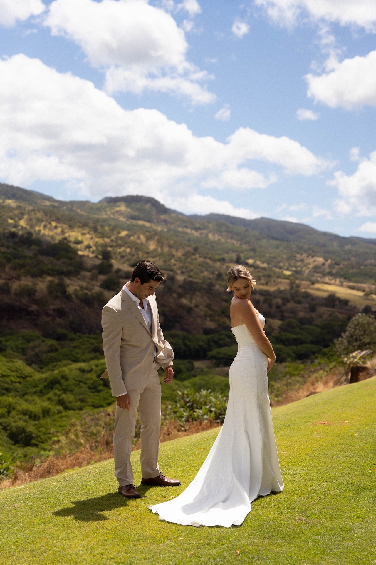 Bride and groom sharing a quiet moment on a hill overlooking the mountains at Kaʻala Vista wedding venue.