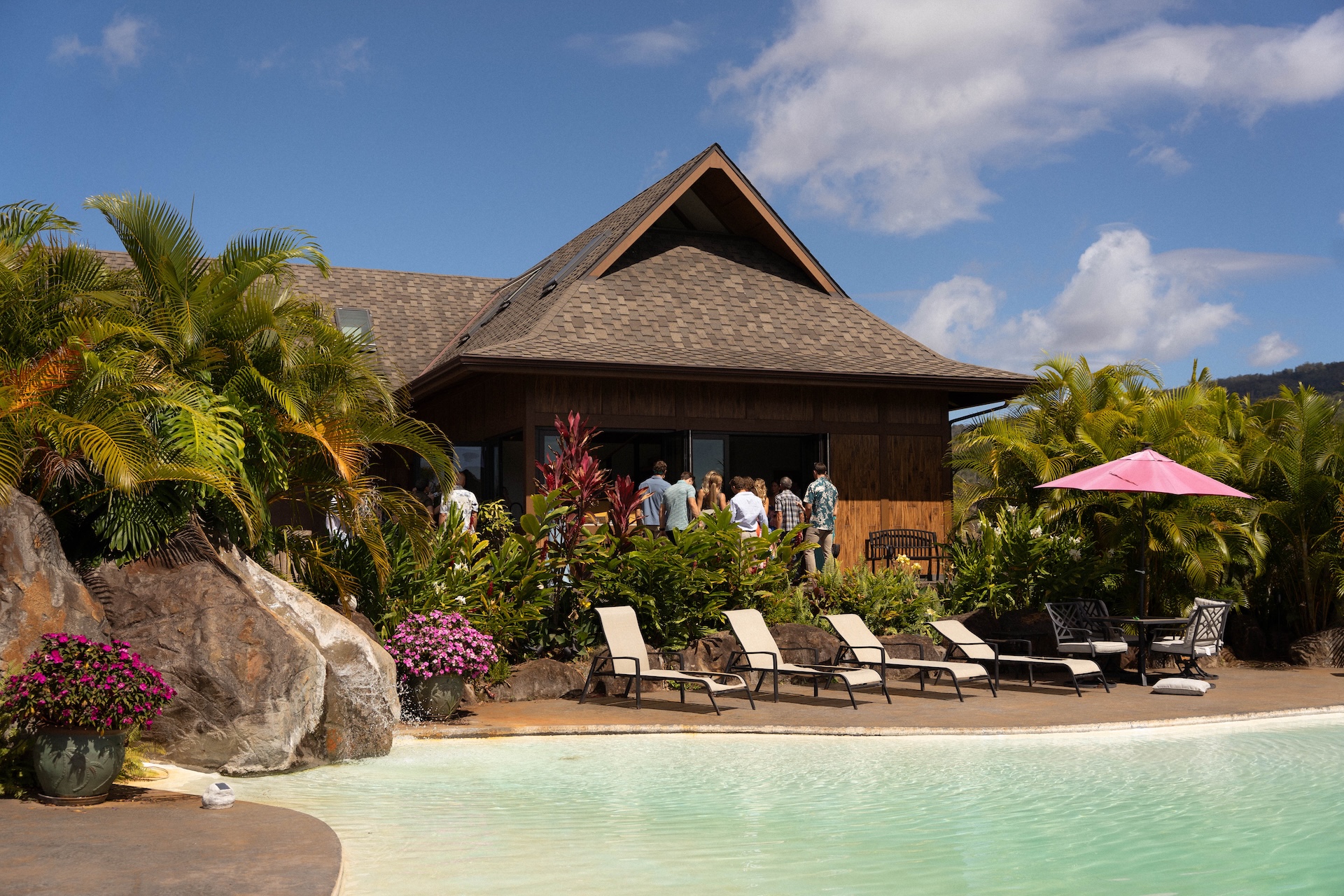 Close-up of white and blush floral arrangements on the ceremony lawn for a Hawaii destination wedding.