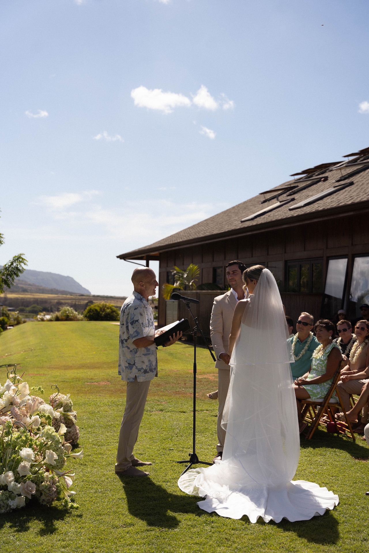 Bride and Groom looking at the officiant while holding hands at the alter for their hawaii destination wedding.