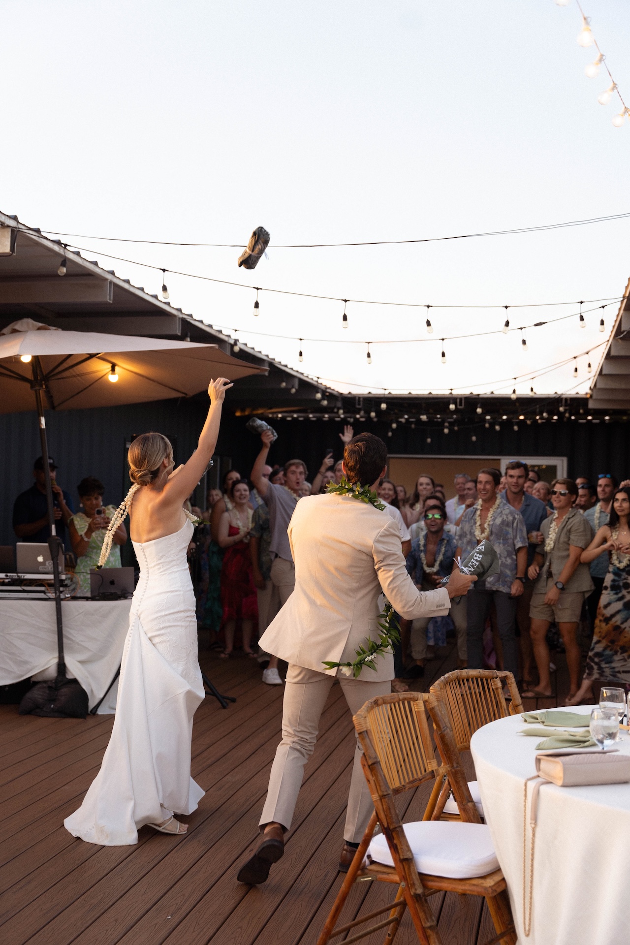 The bride and groom throw their custom t shirts toward a crowd of guests during the reception.