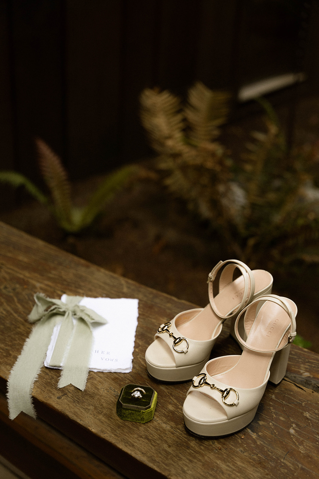 Bridal details including Gucci heels, vow books, and a ring box, styled at their Big Sur wedding venue.