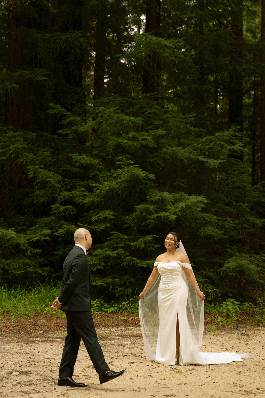 Bride and groom smiling during their Big Sur wedding ceremony surrounded by towering redwoods at one of the most stunning Big Sur wedding venues.
