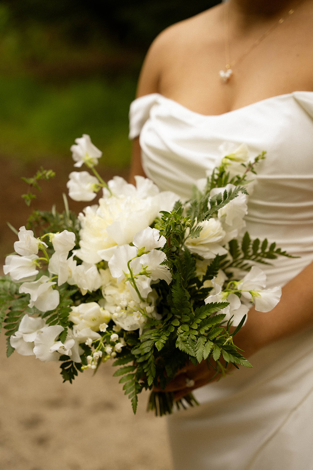 Bride holding a bouquet of white florals and lush greenery at her intimate Big Sur wedding.