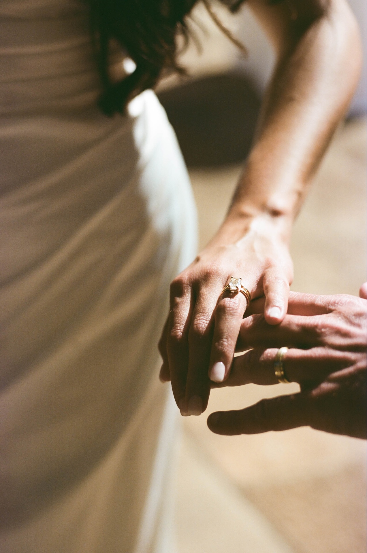 A close-up of the groom placing a ring on the bride’s hand, her emerald-cut diamond glowing in the light — a timeless moment by a destination wedding photographer.