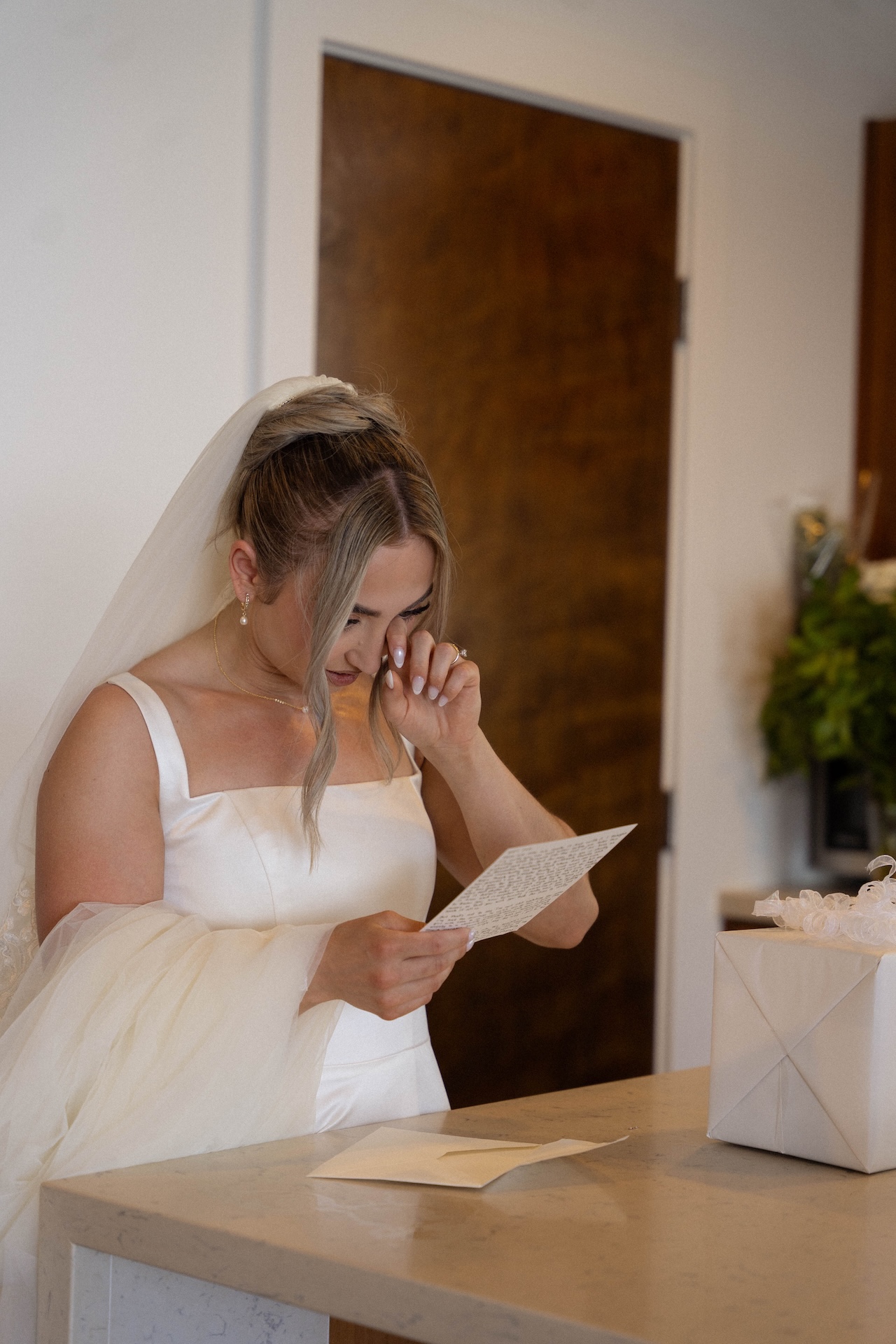 The bride wiping a tear as she reads the grooms vows at their Airbnb wedding.