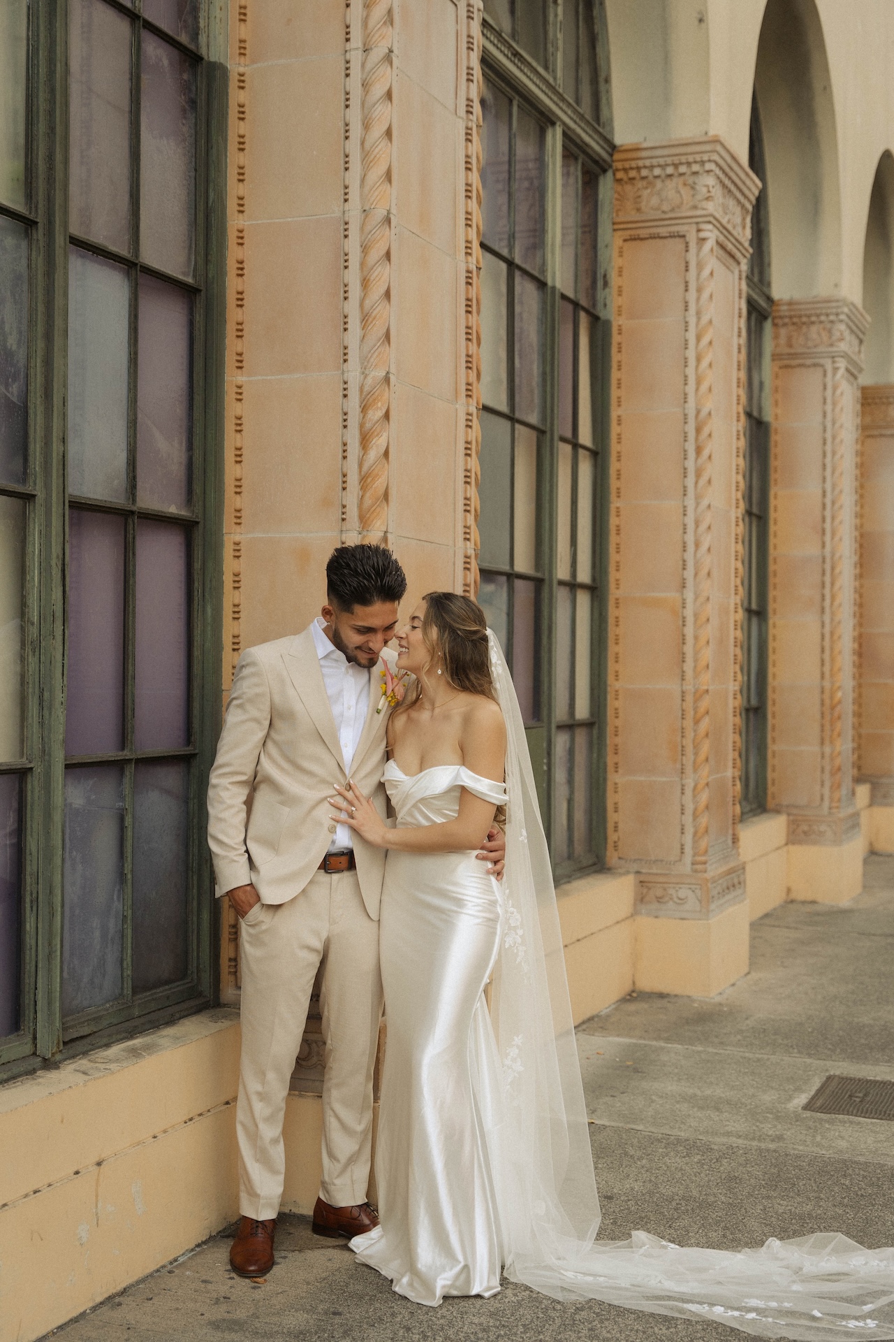 The couple sharing an intimate moment against a historic building during their destination wedding in Hawaii.


