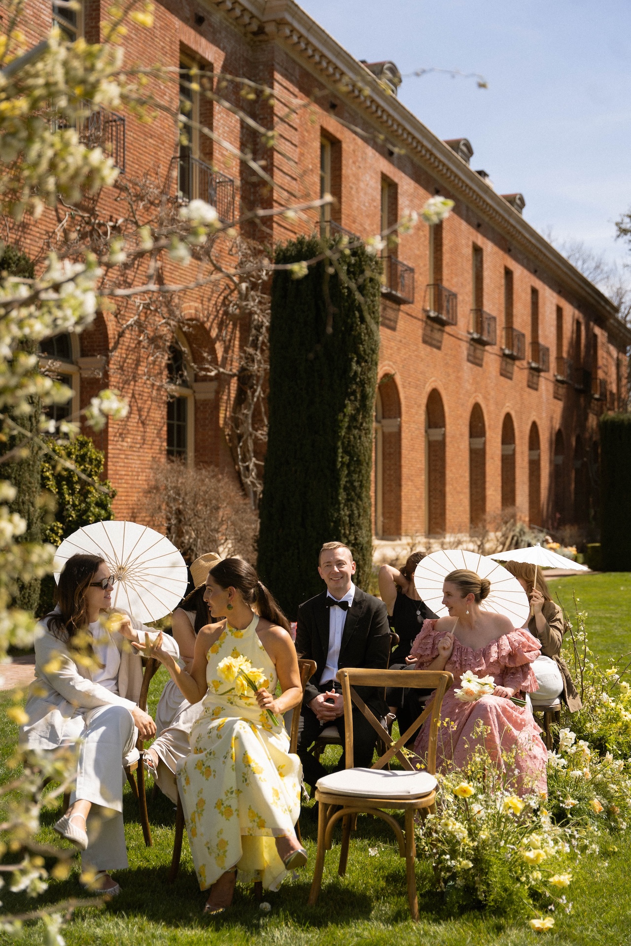 Guests chatting and laughing before the ceremony, dressed in colorful and elegant wedding attire.

