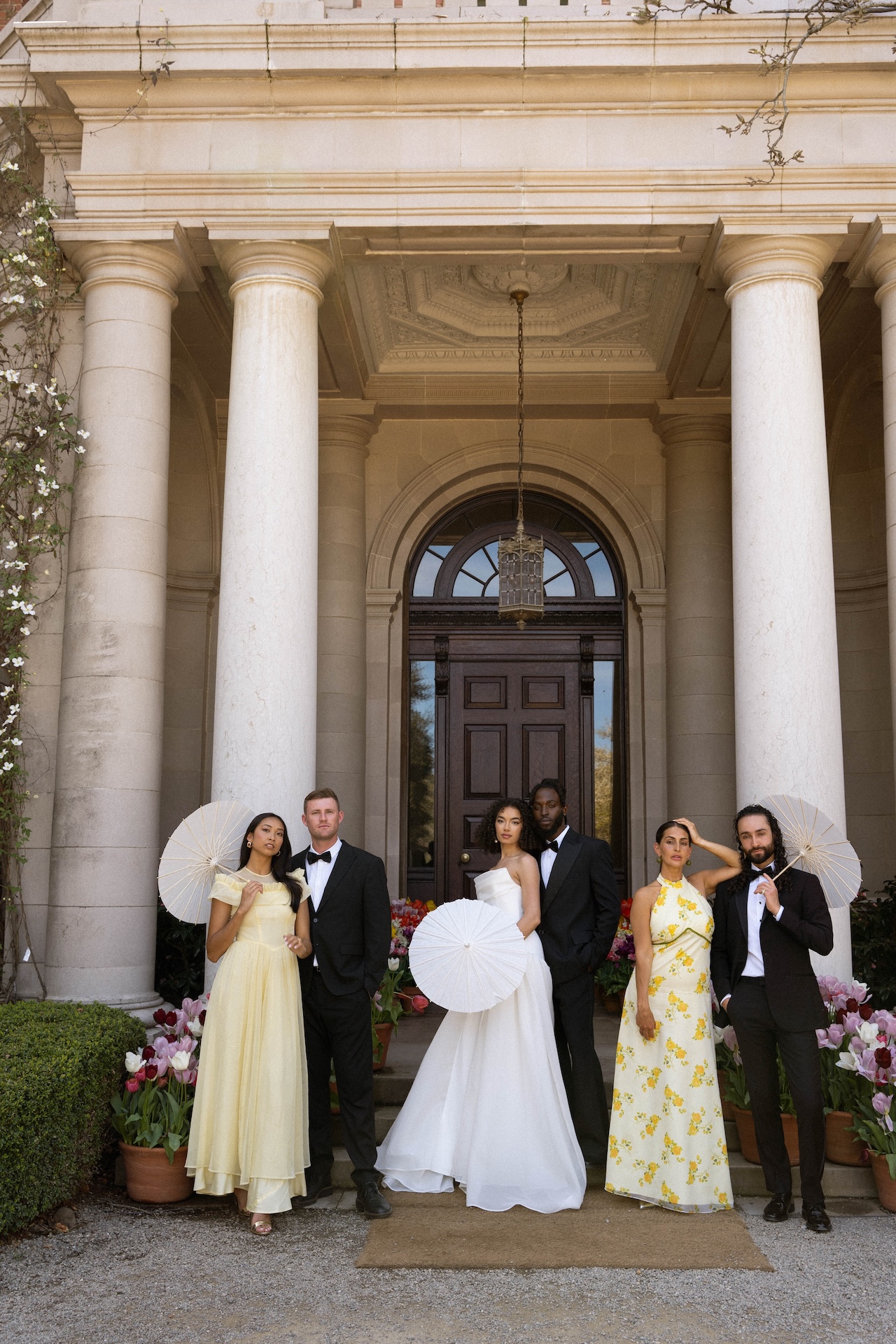 A stylish wedding party posing on the grand entrance steps of one of the most timeless and elegant wedding estate venues.

