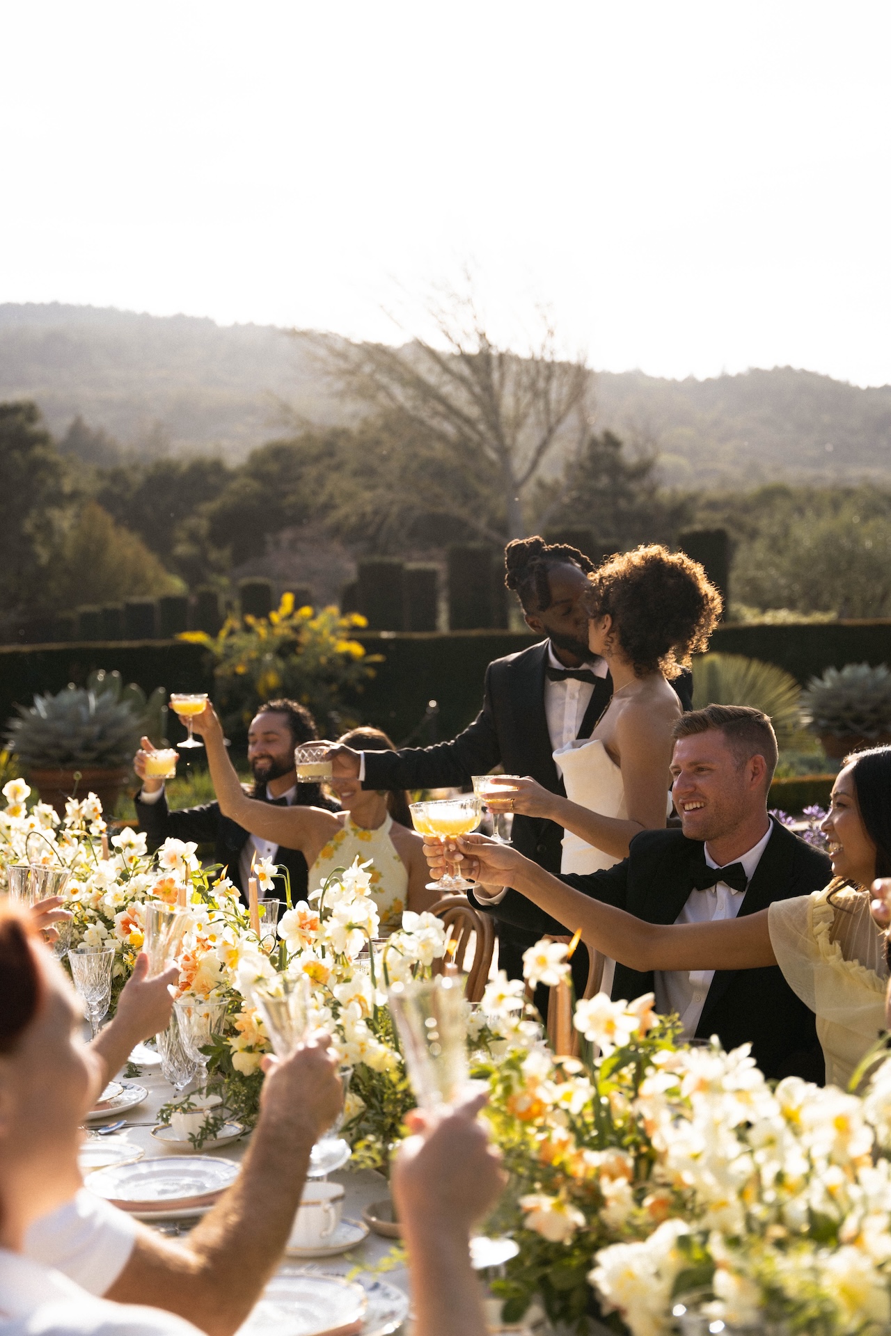 Guests raising their glasses in a celebratory toast at a beautifully set reception table at one of the most elegant wedding estate venues.

