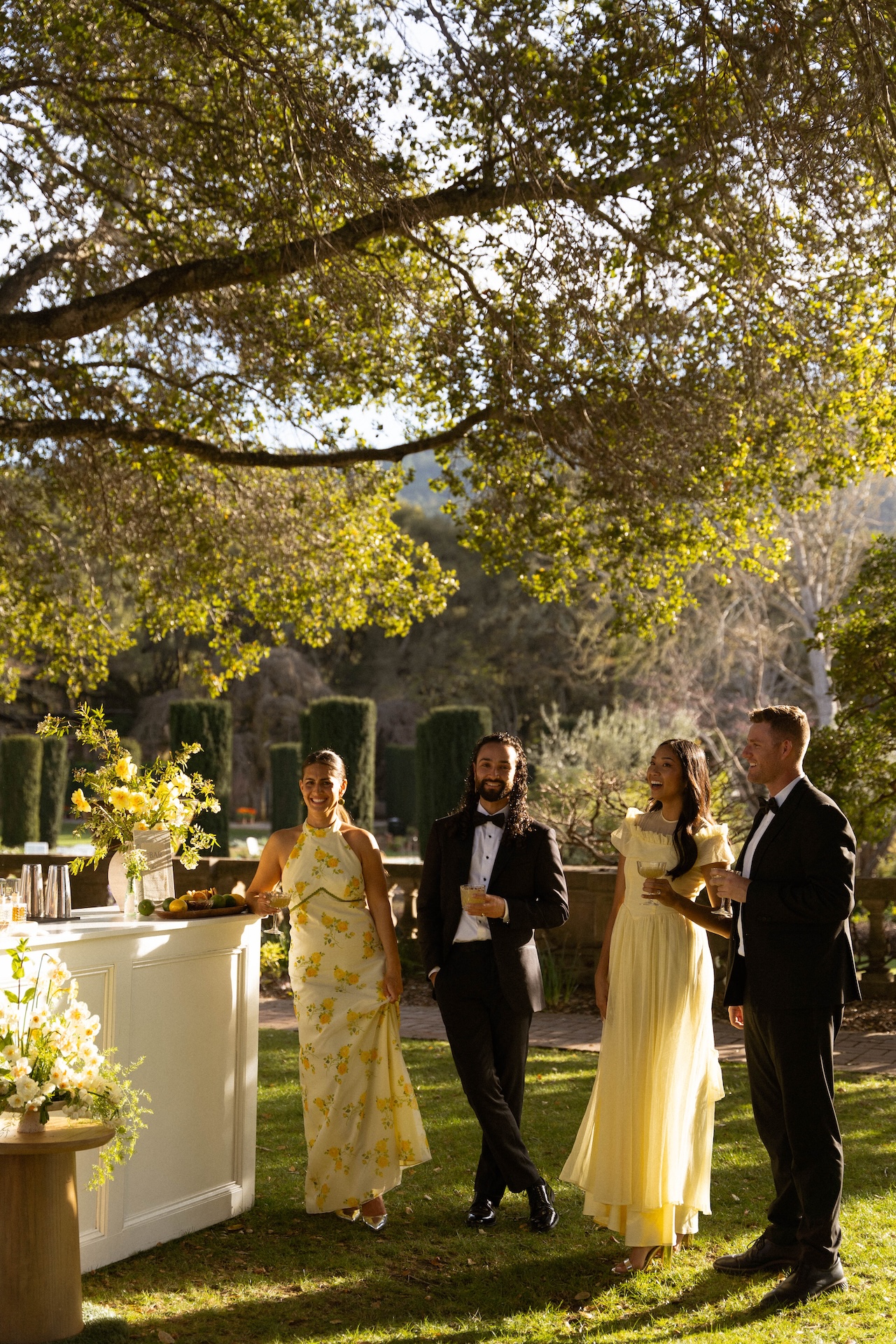 Wedding party members gathered near the outdoor bar, sharing drinks and enjoying the post-ceremony celebration.

