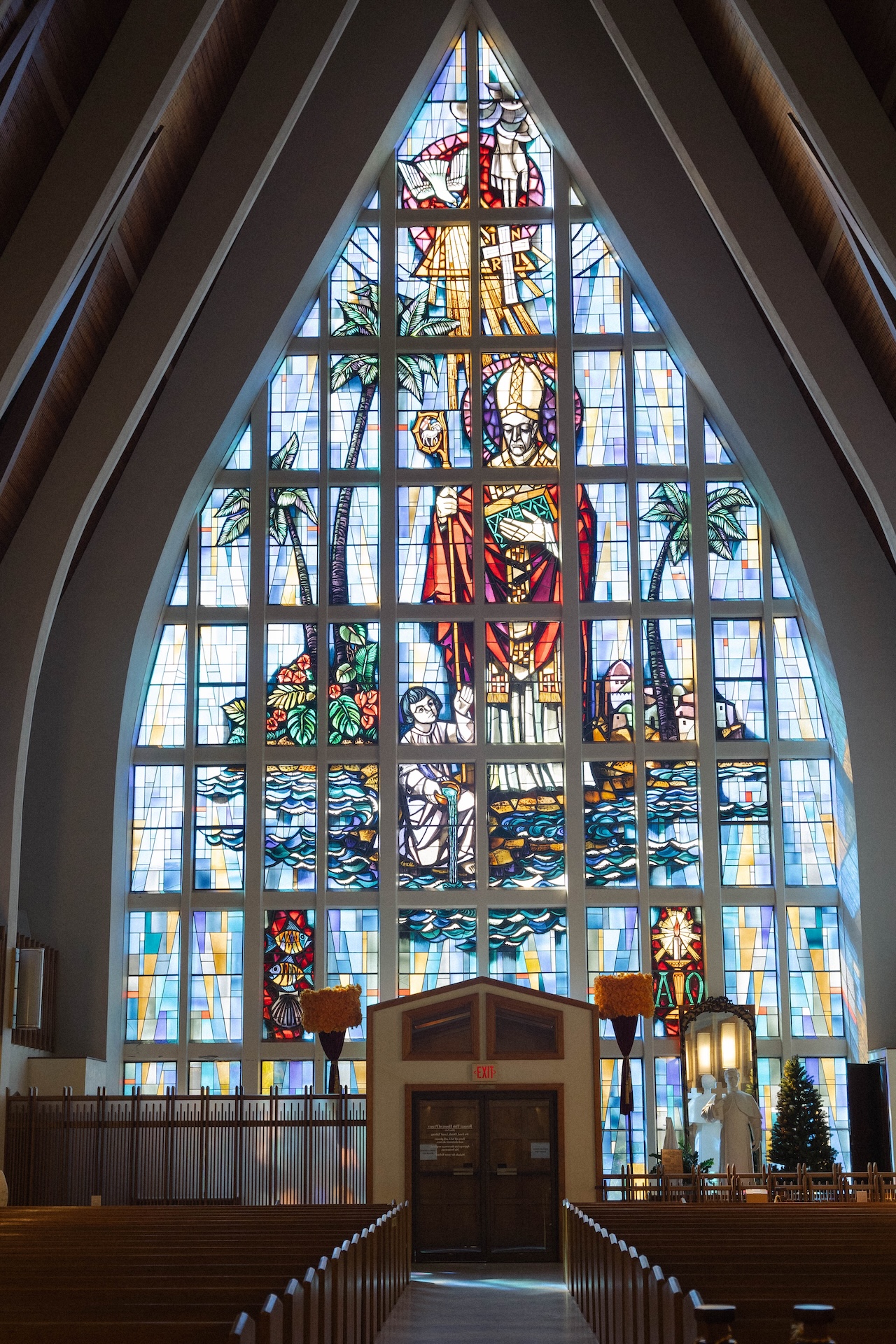 Stained glass window inside a church with bright tropical details.

