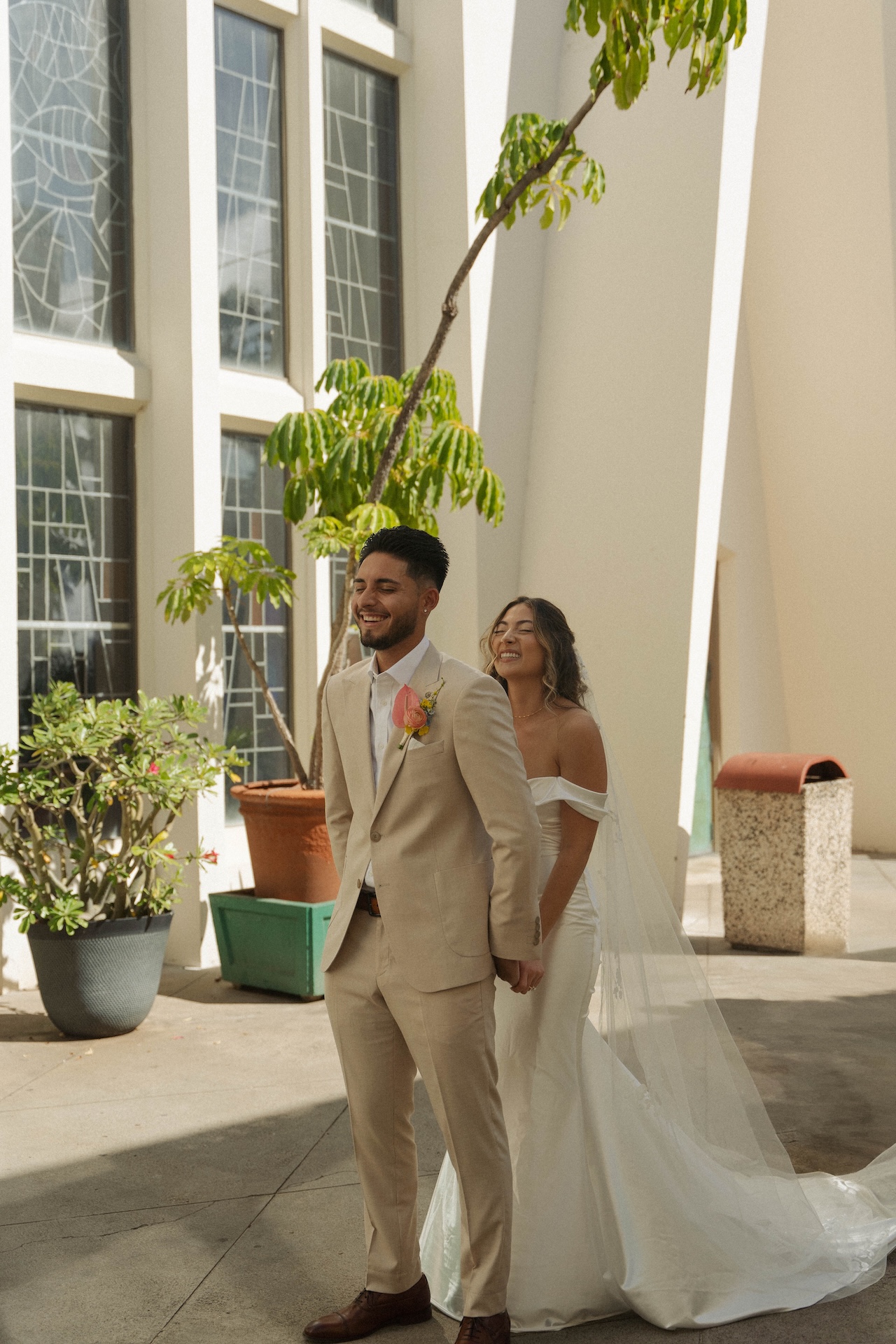 Bride walking up behind the groom with a huge smile during their destination wedding in Hawaii first look moment.

