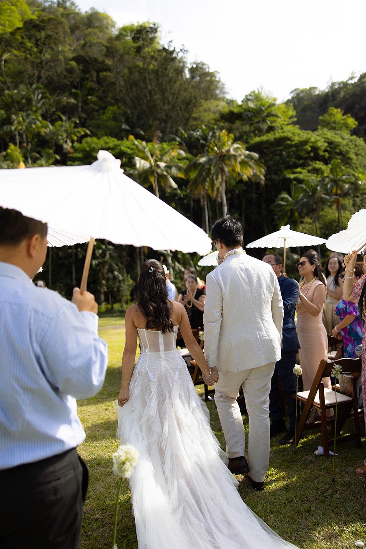 Bride and groom walking hand-in-hand through the aisle during the ceremony as guests watch and celebrate