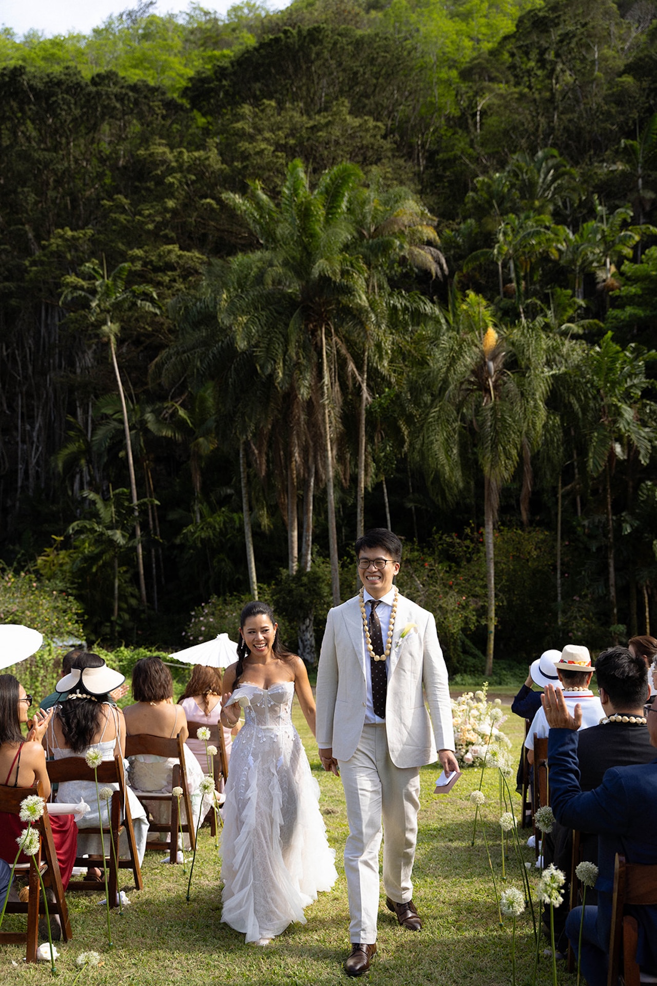 Couple walking down the aisle together after the ceremony, beaming with joy while guests cheer them on — a magical moment in one of the island’s most hidden intimate wedding venues