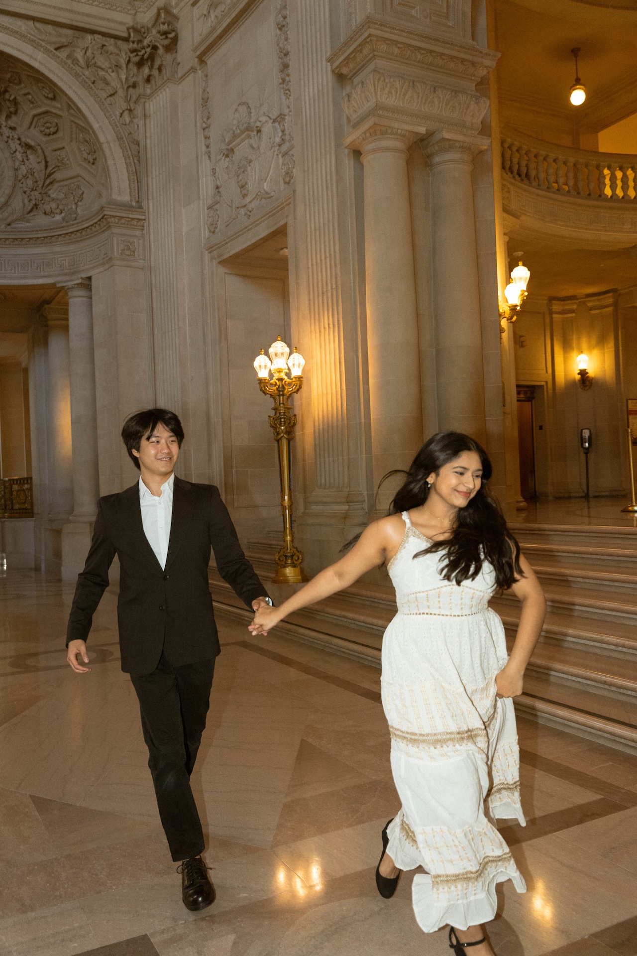 The bride and groom running through the hallways of the San Francisco City Hall for their San Francisco City Hall Wedding