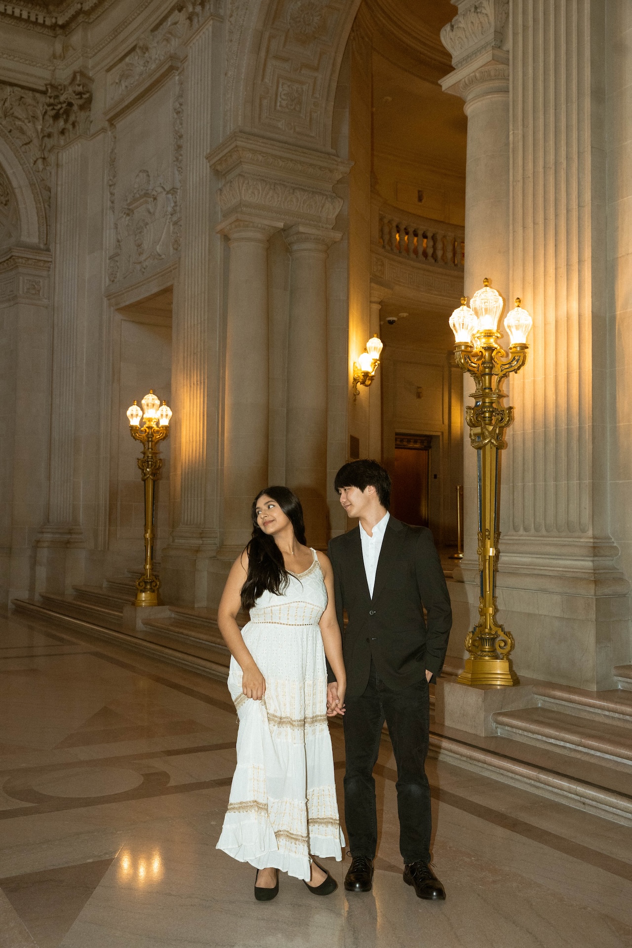 The bride and groom looking away from each other and standing closing together, an iconic location for a San Francisco City Hall wedding.