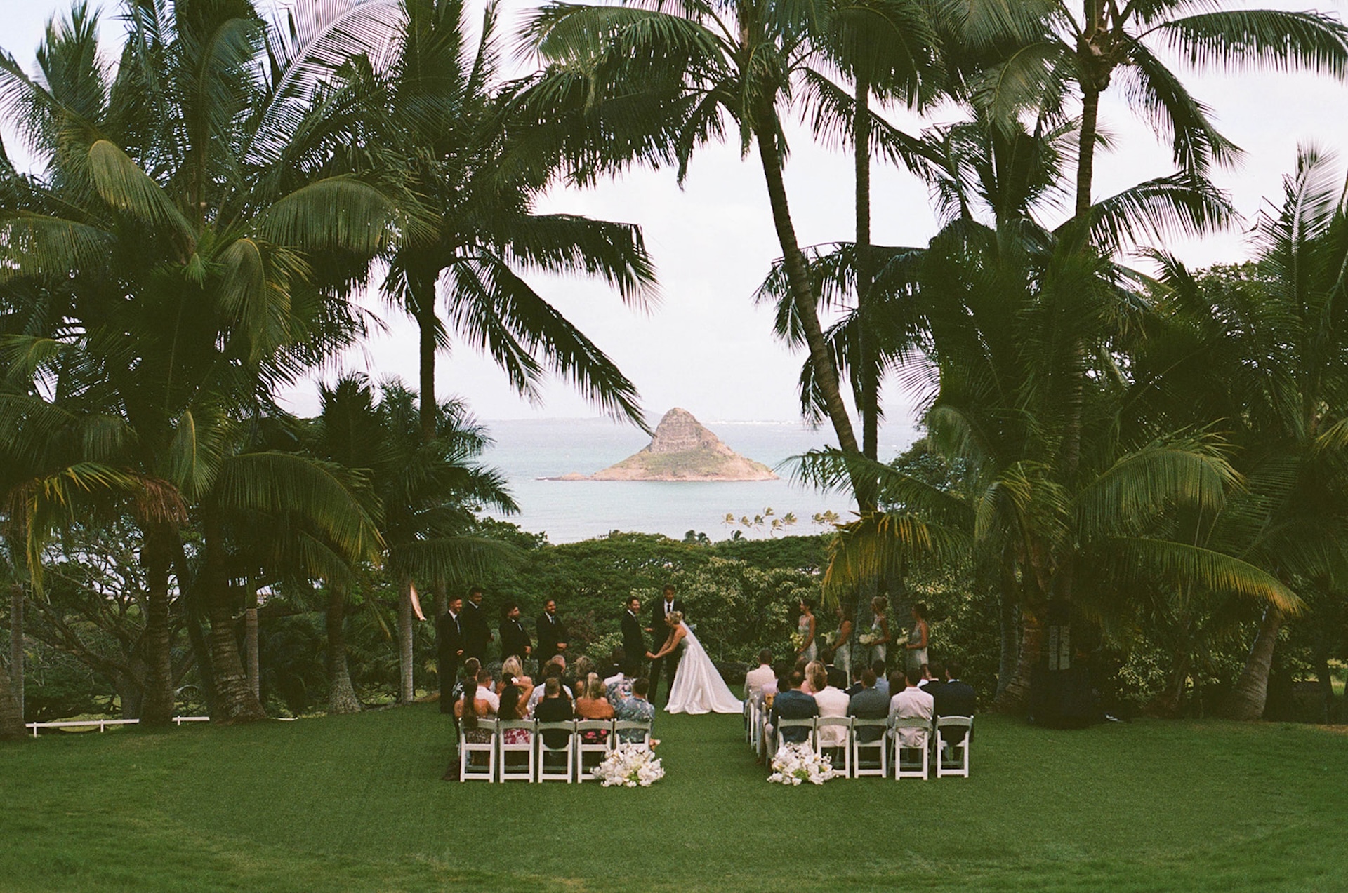 Wide angle shot of the wedding ceremony at Kualoa Ranch, overlooking the ocean and Mokoliʻi (Chinaman’s Hat).