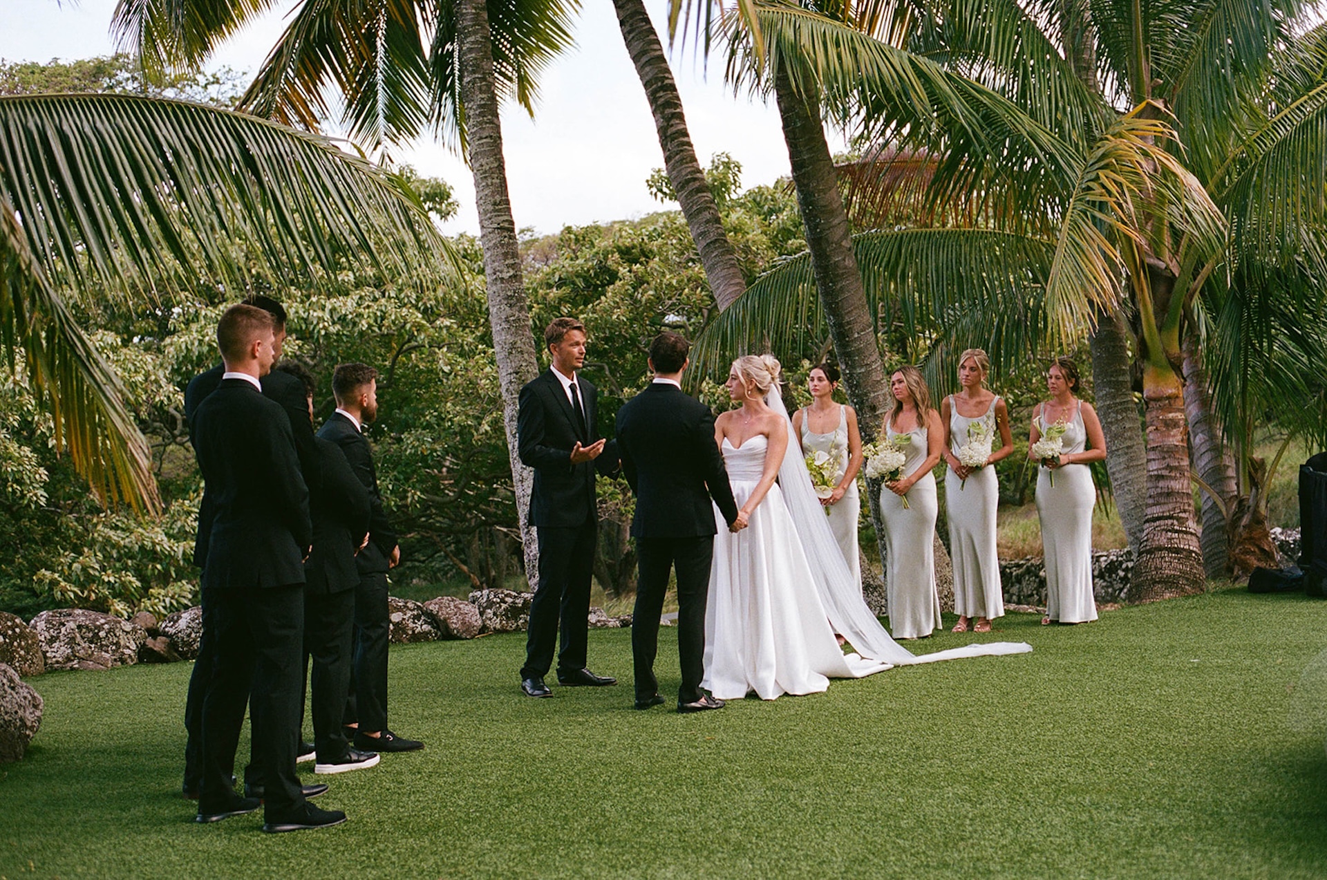 The bride and groom holding hands and listening to the officiant during their wedding ceremony.