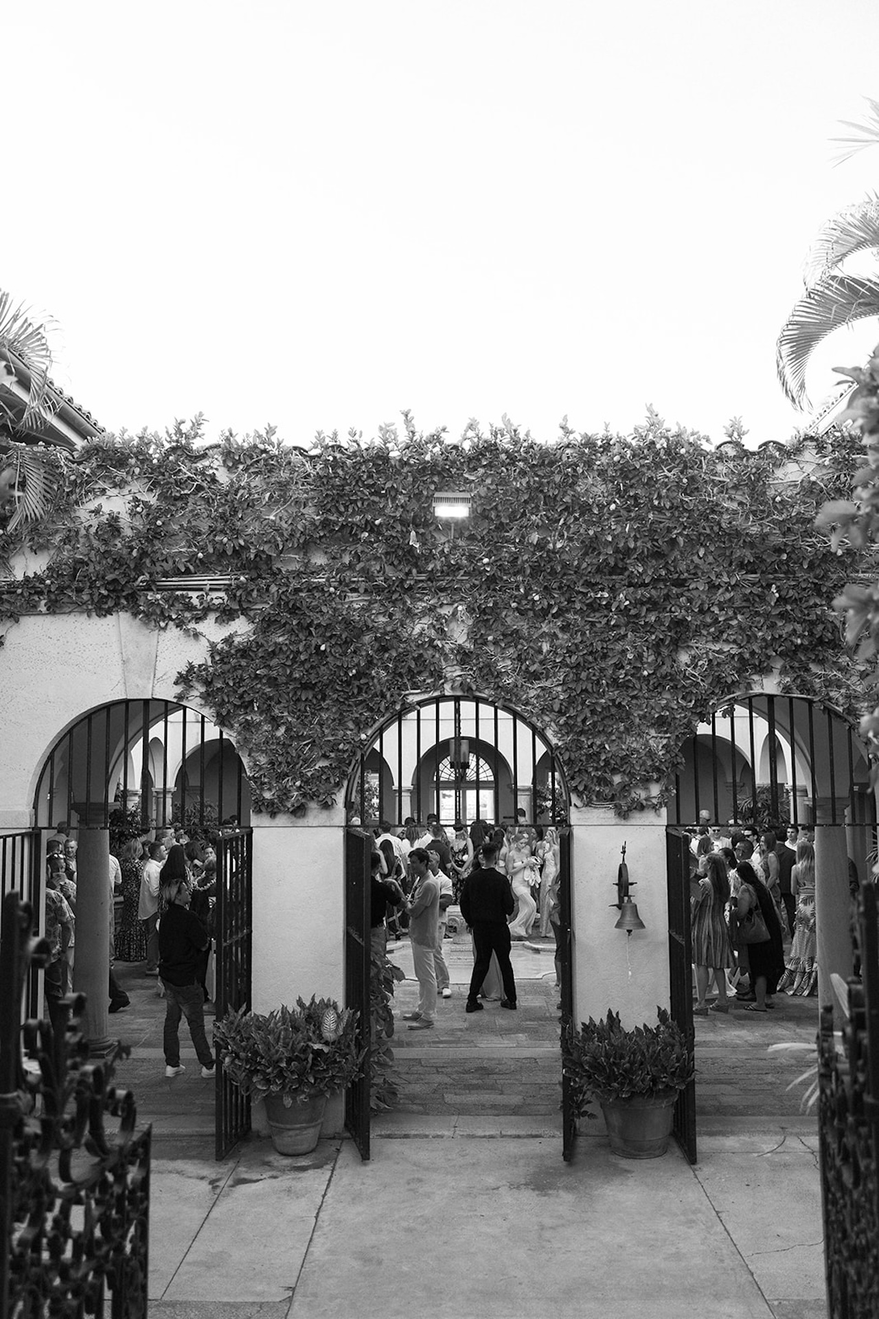 A lively cocktail hour scene under Mediterranean-inspired arches at one of the best destination wedding locations.