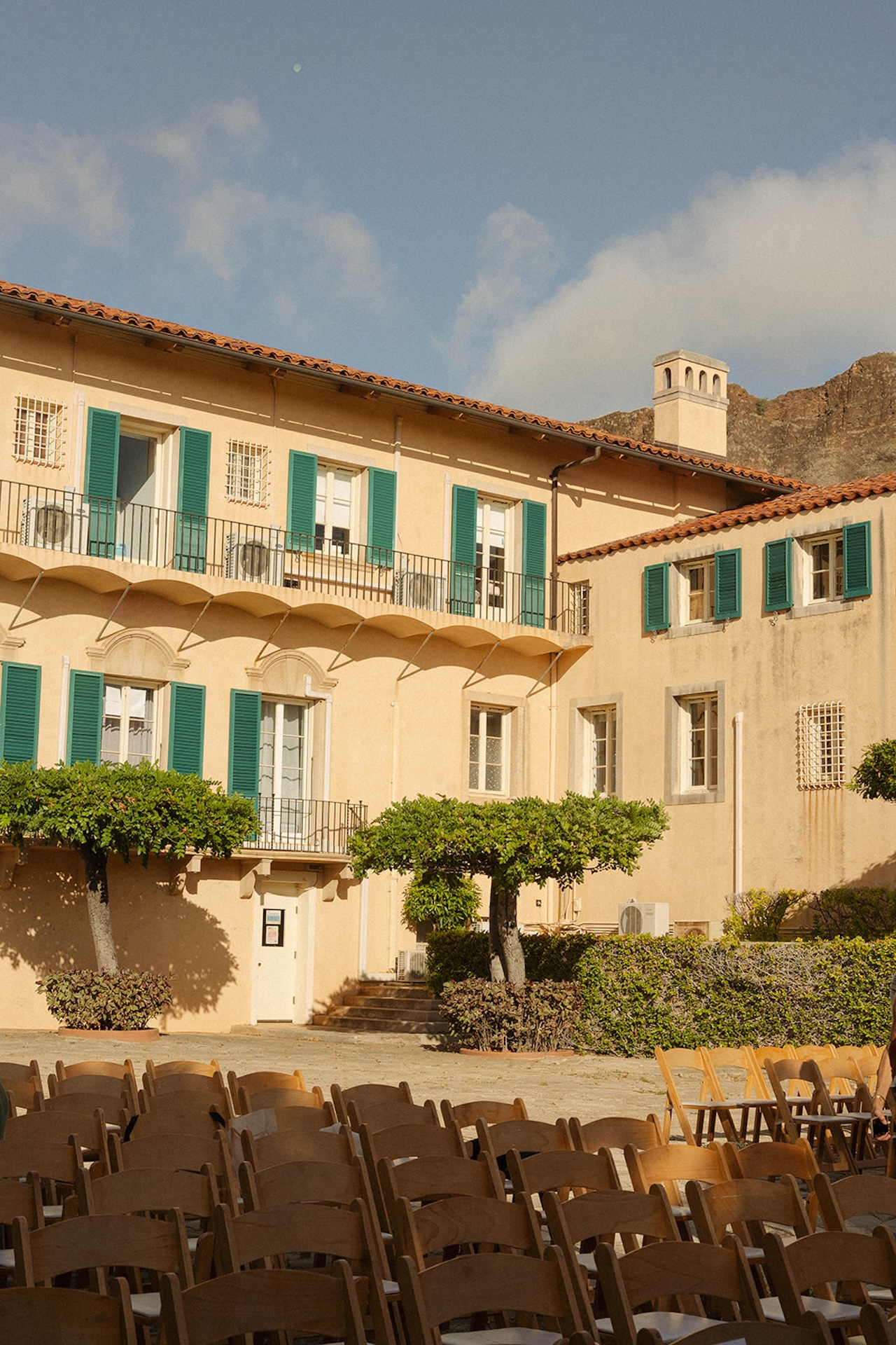Rows of wooden chairs set for an outdoor ceremony at one of the best destination wedding locations, surrounded by golden light.