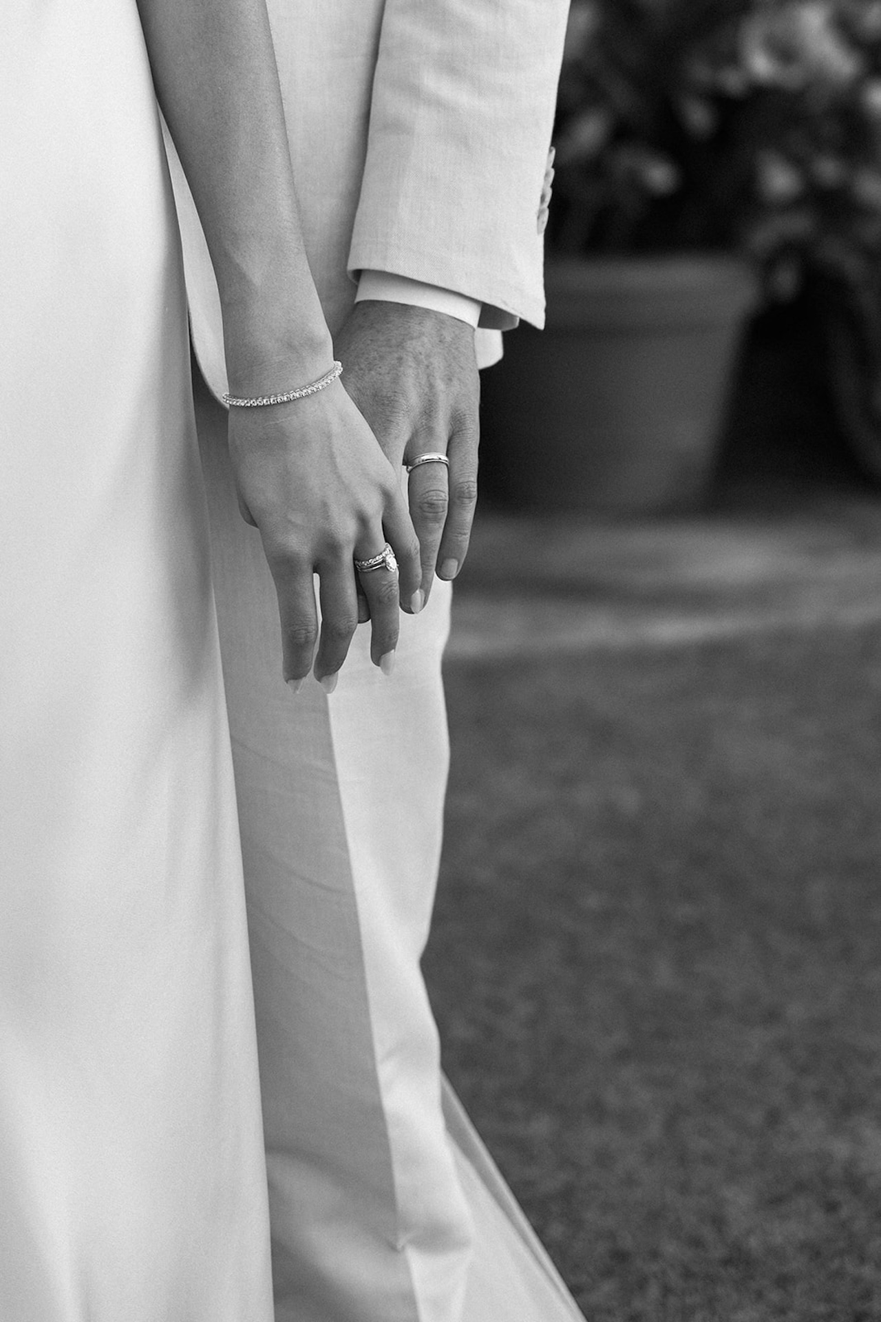 A close-up black and white detail of the couple’s hands intertwined, symbolizing love and unity from their intimate wedding day.