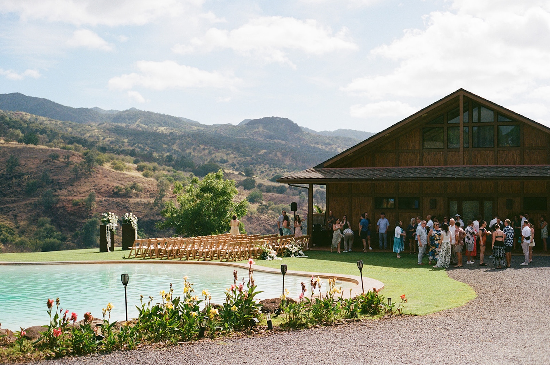 Wedding ceremony setup beside a pool with floral decor and mountain views, capturing the charm of Wedding Venues in Hawaii.