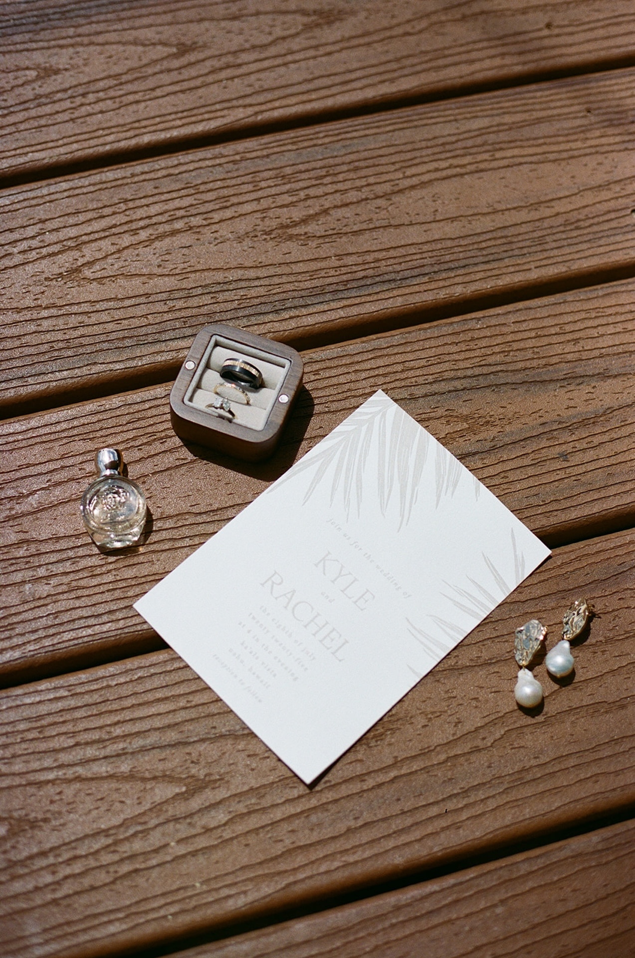 Elegant flatlay of wedding details including rings, perfume, earrings, and an invitation—captured at one of the most romantic Wedding Venues in Hawaii.
