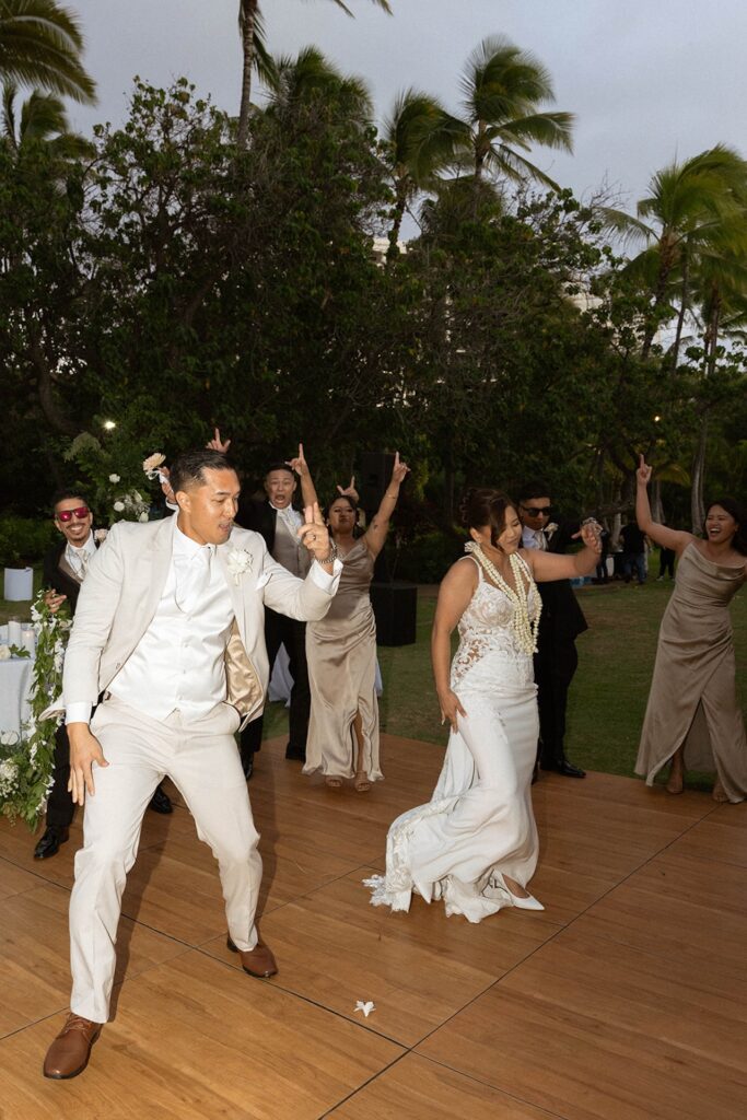 Bride and groom dancing with their wedding party, everyone smiling and full of energy, a must-have celebration on your Destination wedding checklist.