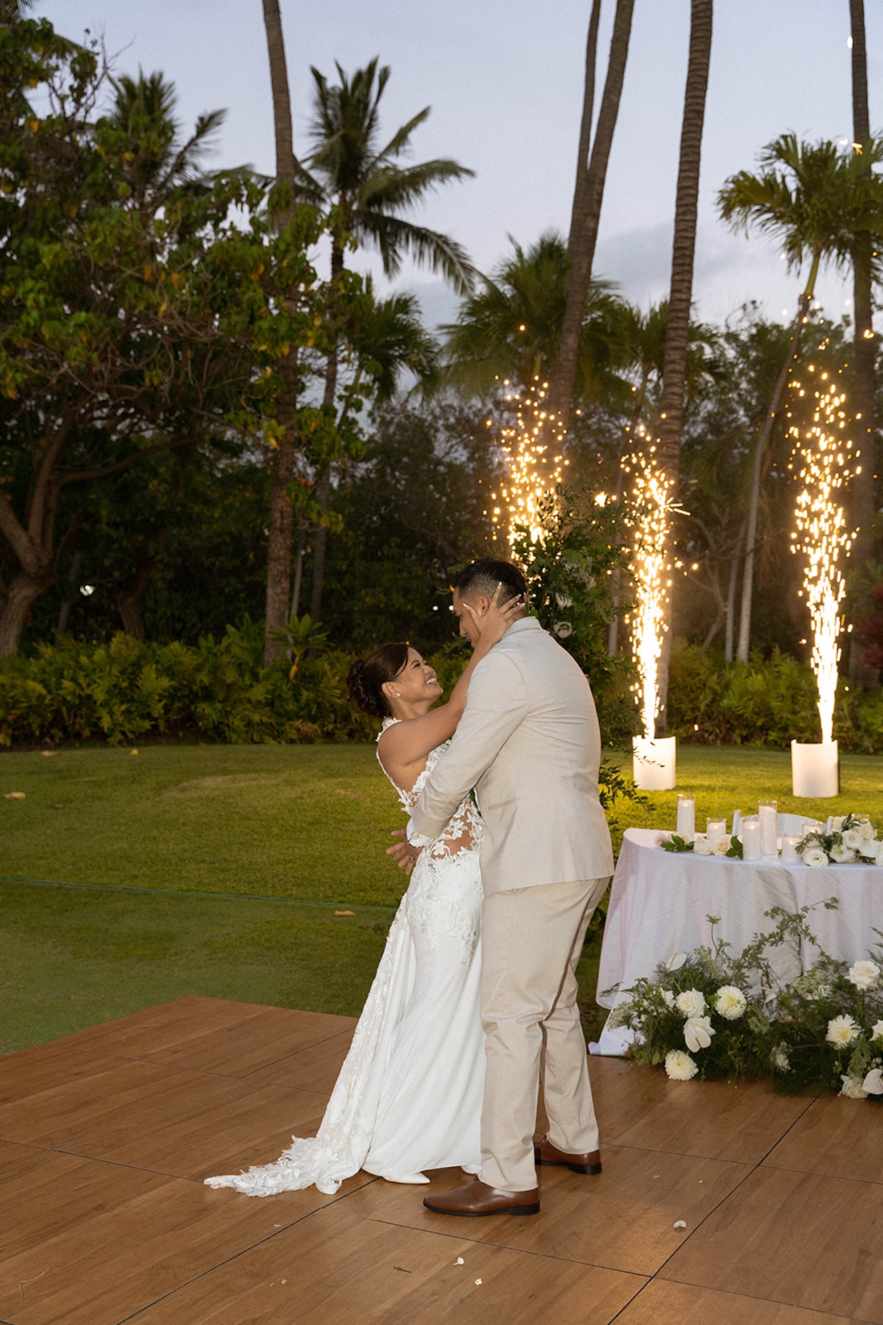 The couple shares their first dance surrounded by sparklers and palm trees, a dreamy reception moment to include in your Destination wedding checklist.