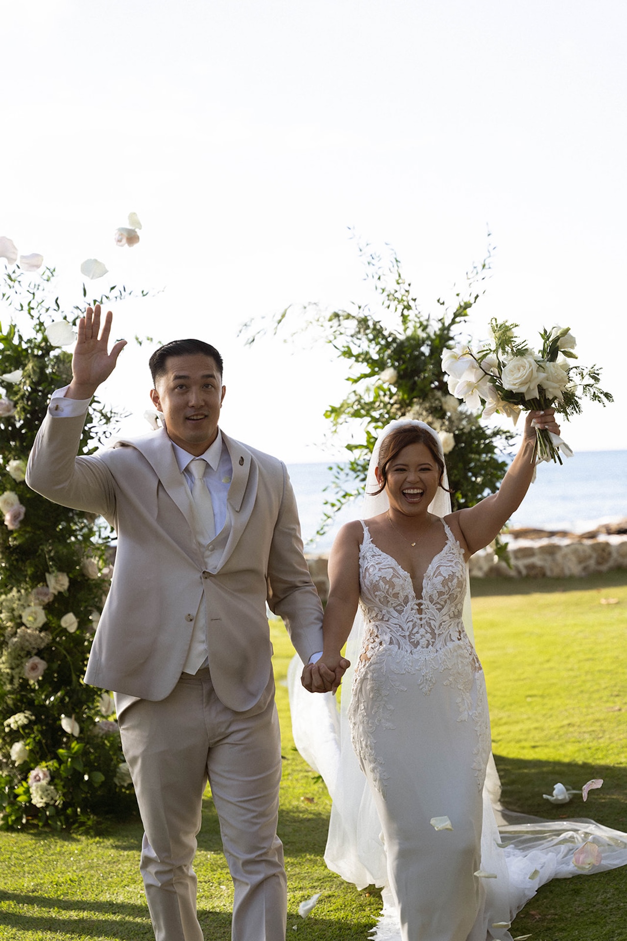 The newlyweds walk hand in hand down the aisle, smiling and waving with the ocean in the background, the kind of joy every Destination wedding checklist aims to capture.