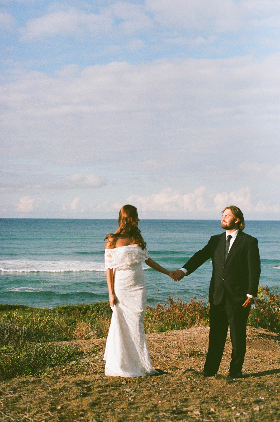 The bride and groom walking along the coast after their private vows for their Kauai wedding bride and groom portraits