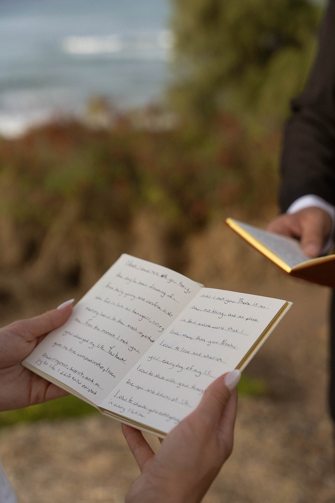 Close-up of the bride holding her handwritten vows during their meaningful Kauai Wedding Planning ceremony by the ocean.