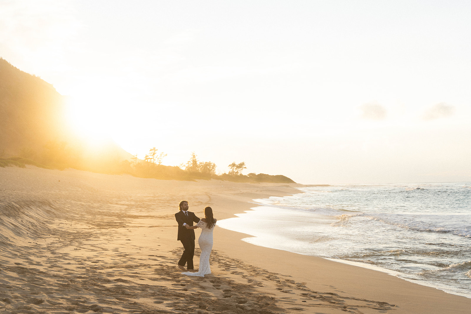 The bride and groom dancing on the beach during their Kauai wedding