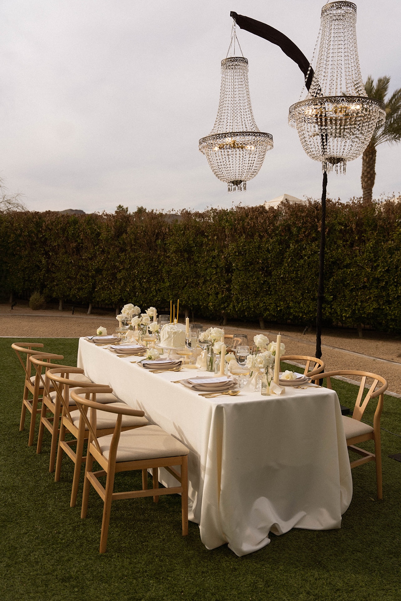 Outdoor reception setup with crystal chandeliers and elegant white florals at one of the top luxury wedding venues.