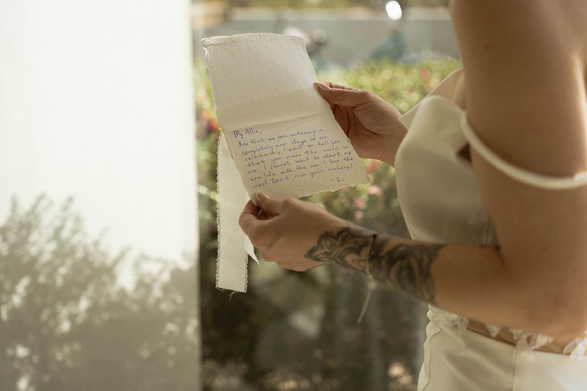 Close-up of the handwritten love letter on textured paper, natural light falling across it.