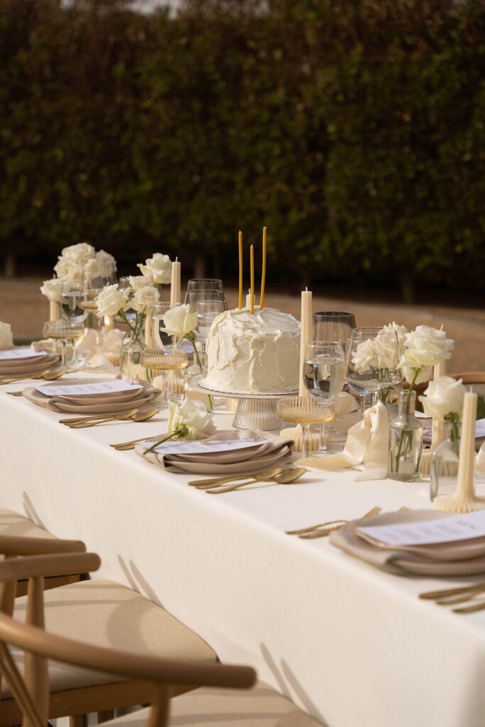 Black and white photo of the dessert table featuring a textured white cake and elegant glass details.
