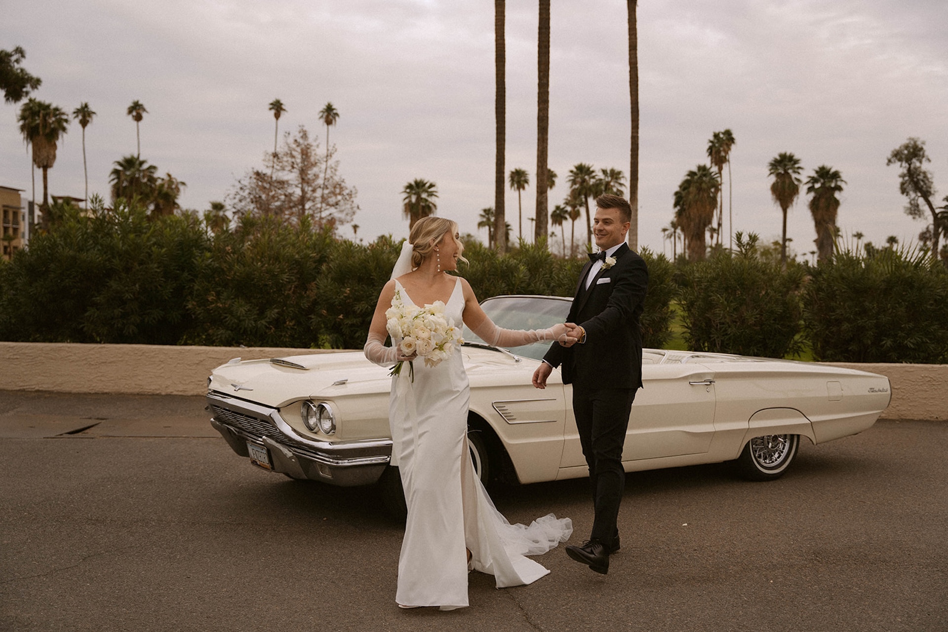 Groom helping his bride step toward him during their intimate wedding portraits.