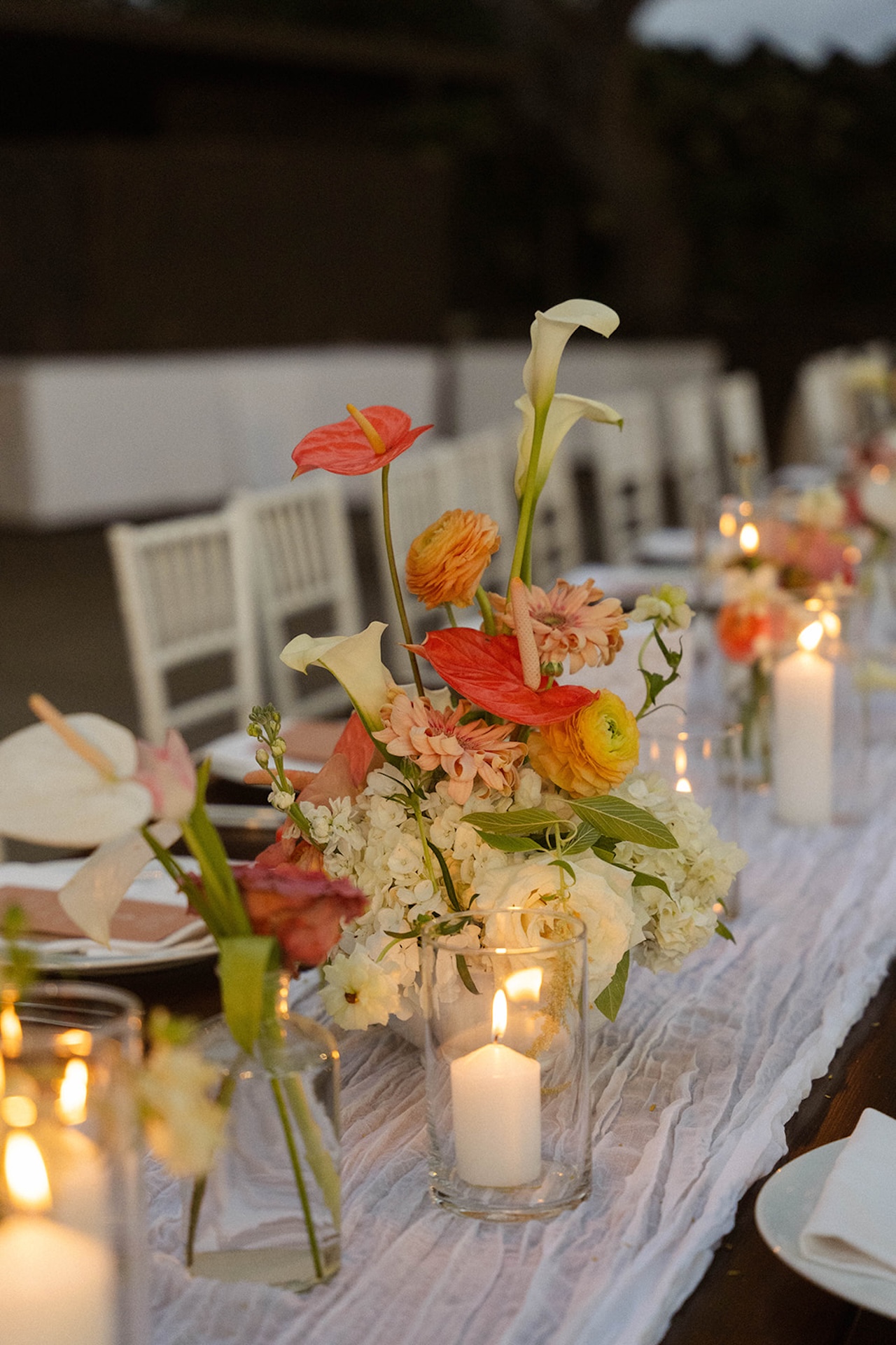 Colorful floral centerpieces line a long reception table, highlighting thoughtful design choices from Big Island wedding planning.