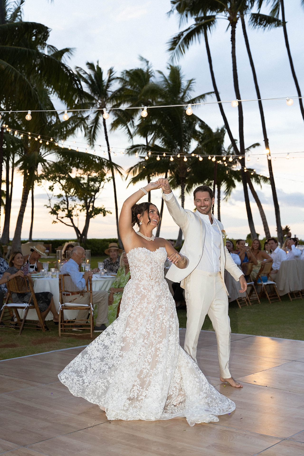 The bride and groom share their first dance on the lawn during their Lanikuhonua wedding.