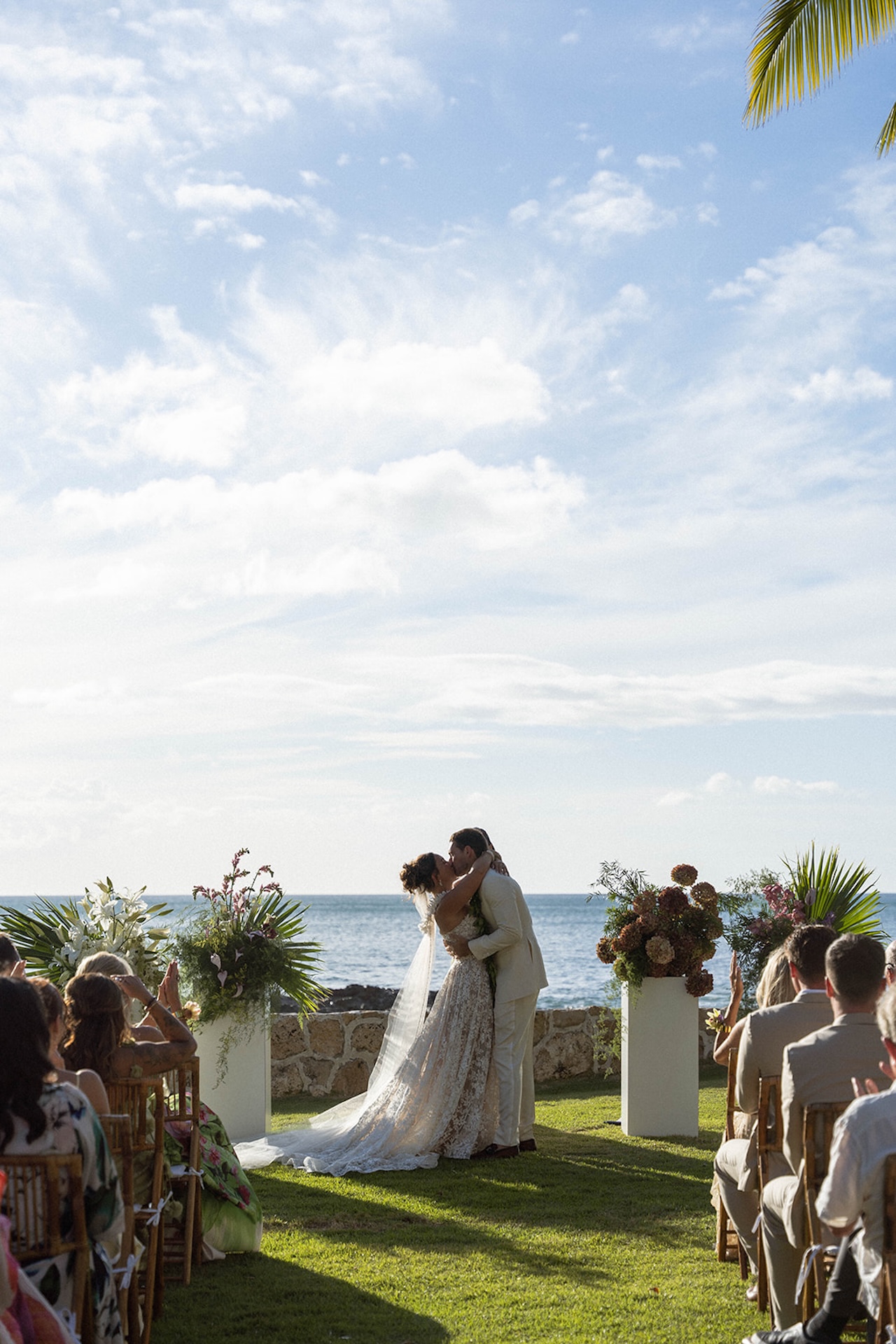 The bride and groom share their first kiss at the oceanfront ceremony.