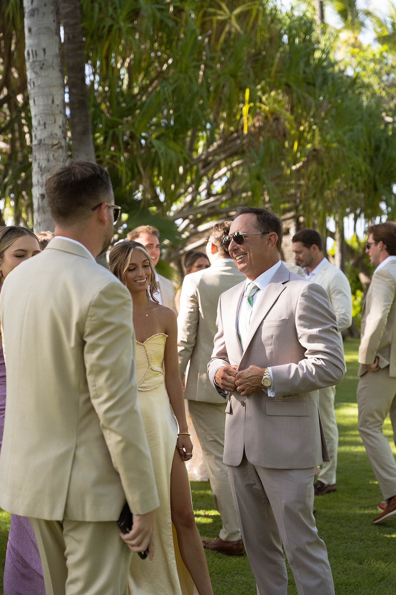Guests chat and enjoy drinks beneath the trees during cocktail hour.