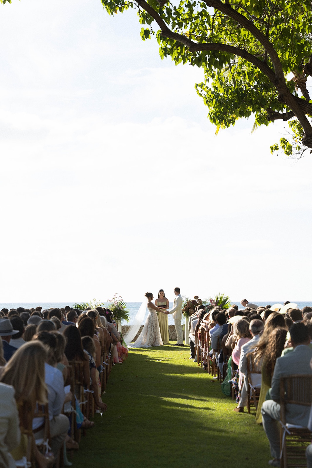 Wide ceremony view with the couple standing at the altar during their Lanikuhonua wedding.