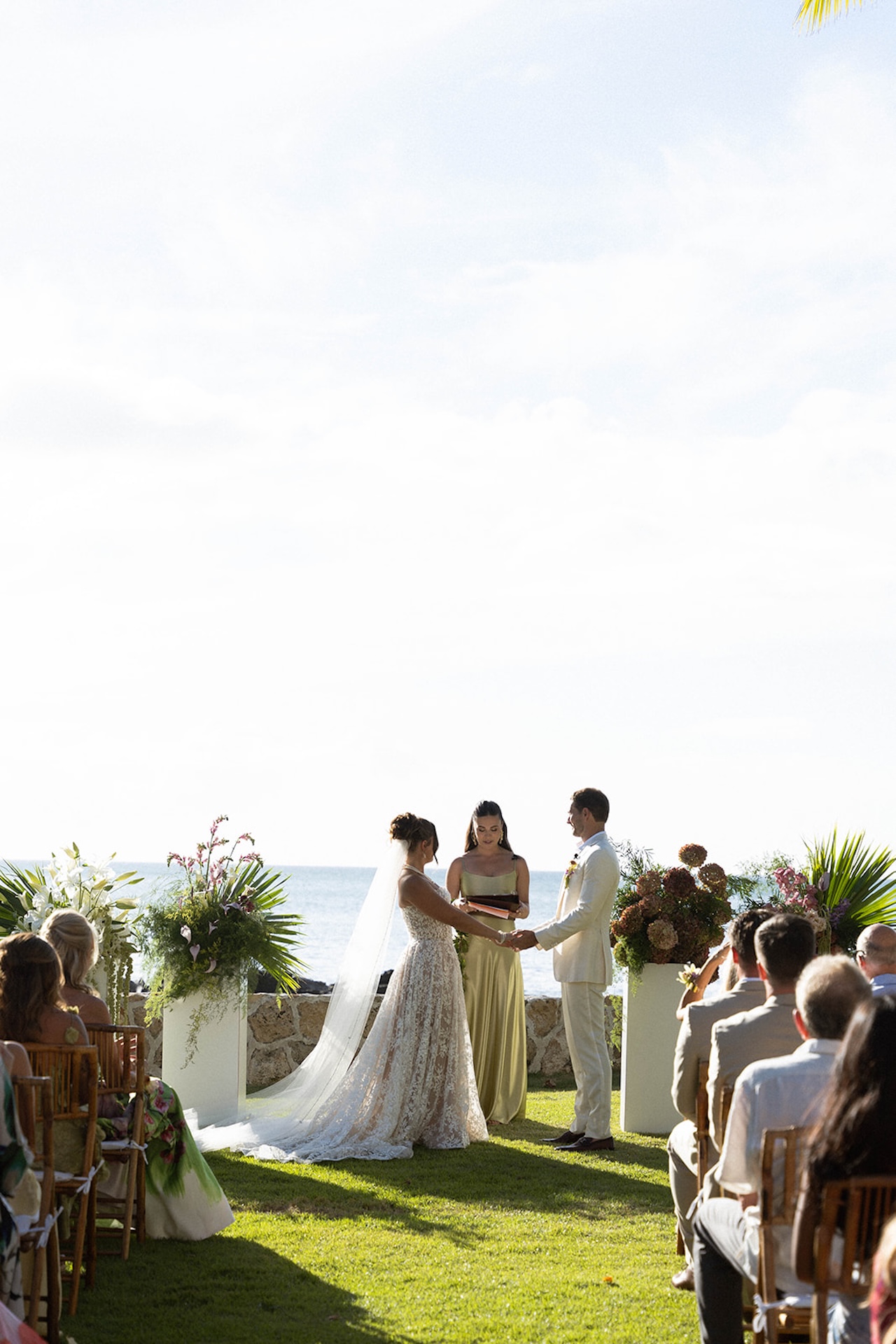 The couple stands at the altar holding hands during their Lanikuhonua wedding ceremony.