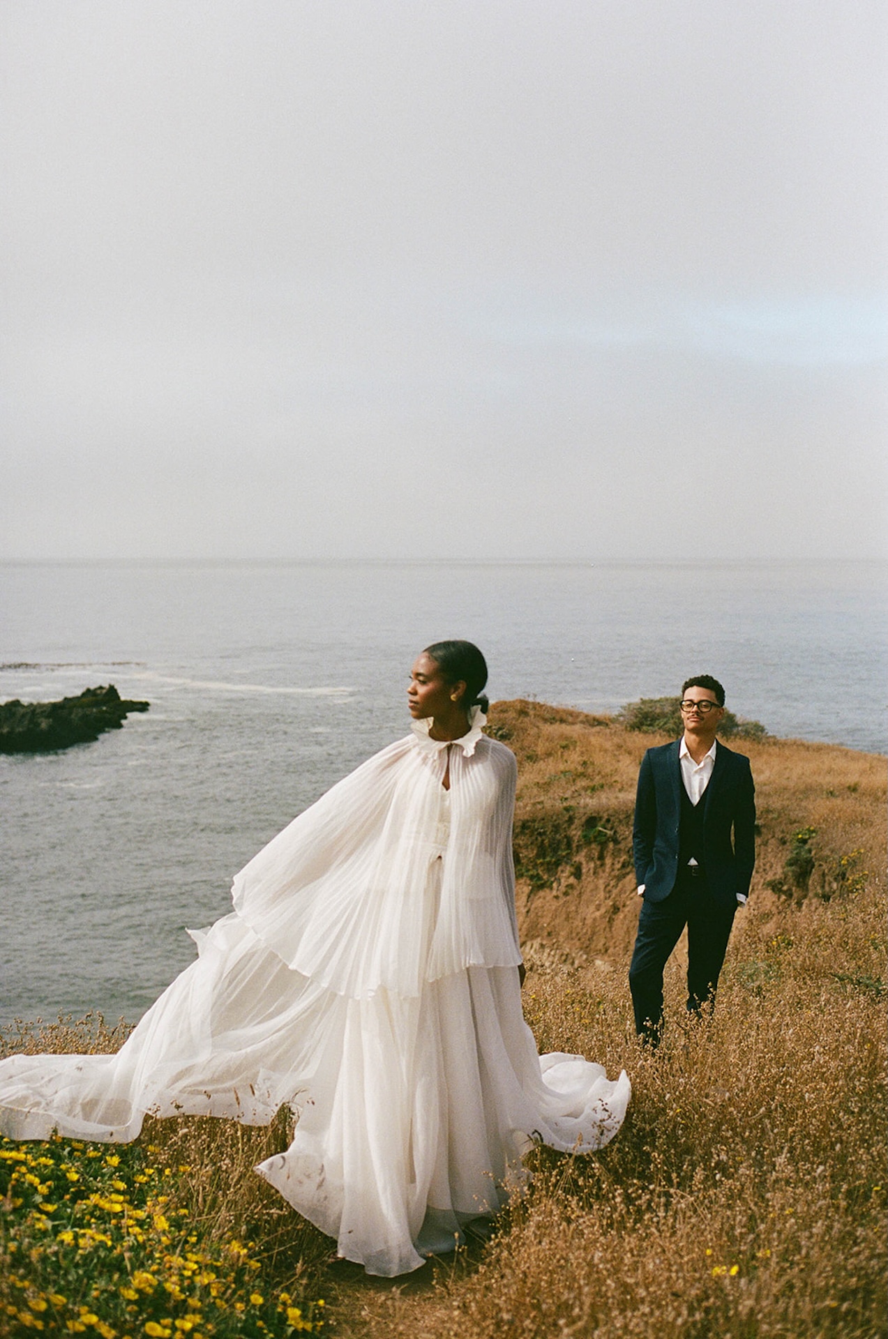 Bride and groom standing on a cliff during their wedding portraits at Sea Ranch Lodge.