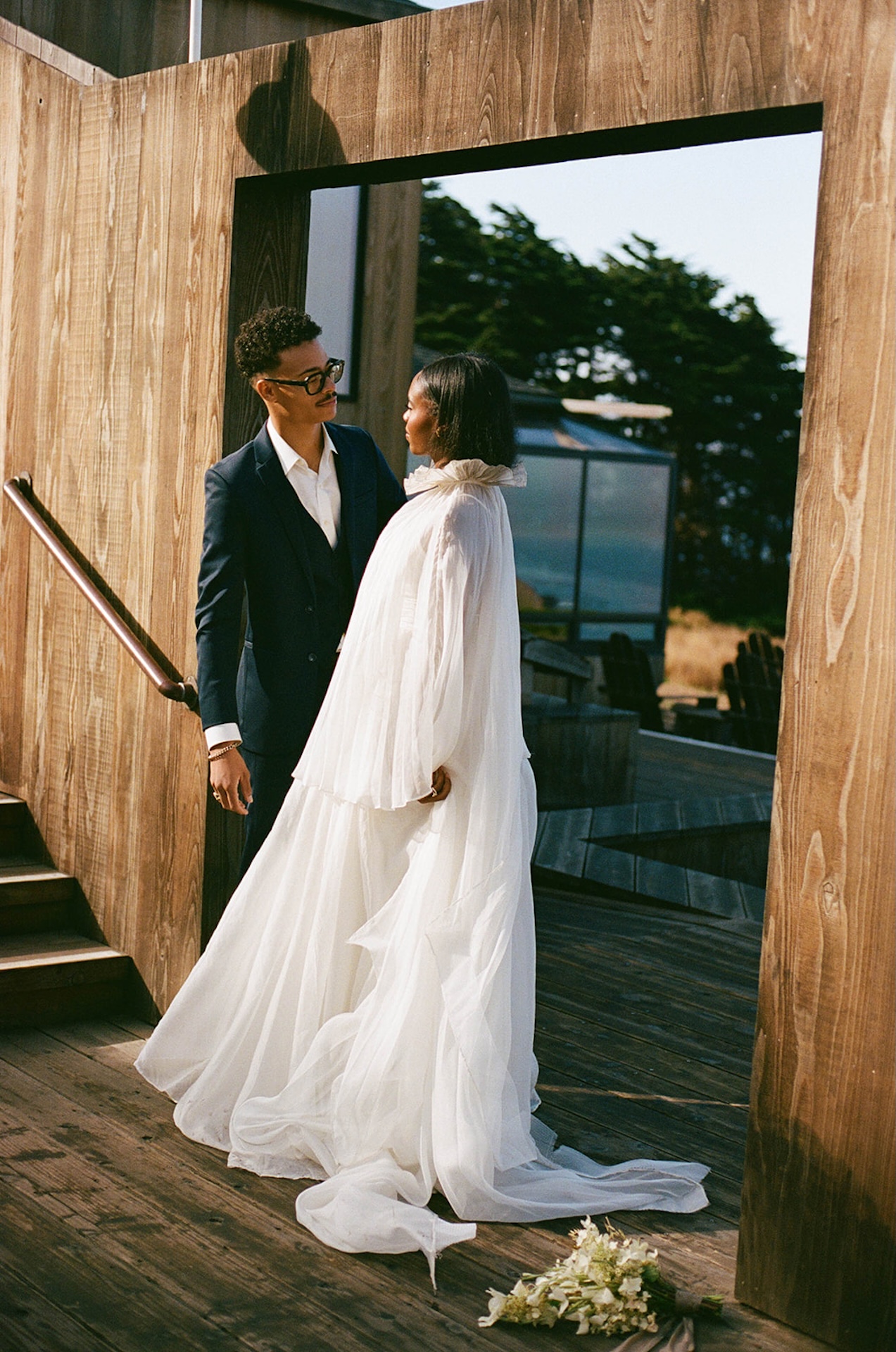 The bride and groom smiling together in a wooden walkway for some elegant bride and groom portraits