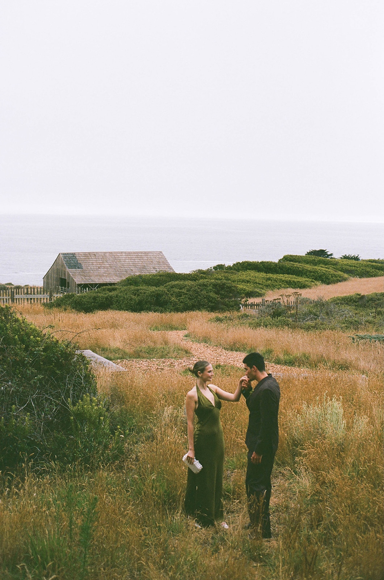 Editorial-style portrait of the couple framed by architecture and landscape, blending natural scenery with refined wedding styling.