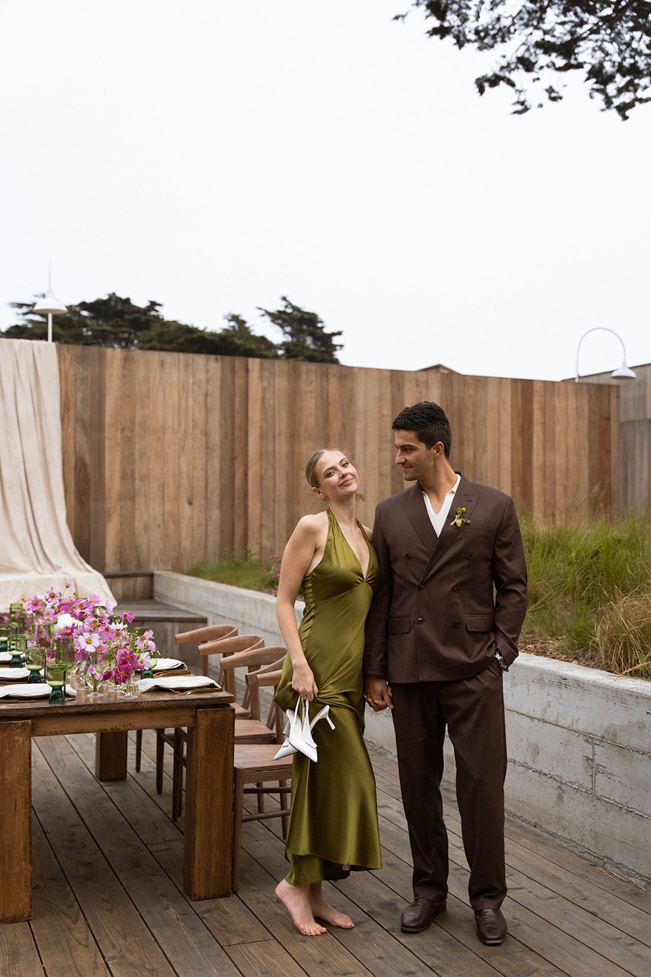 Bride and groom standing barefoot beside a styled dinner table, blending intimacy and thoughtful details while planning a destination wedding.